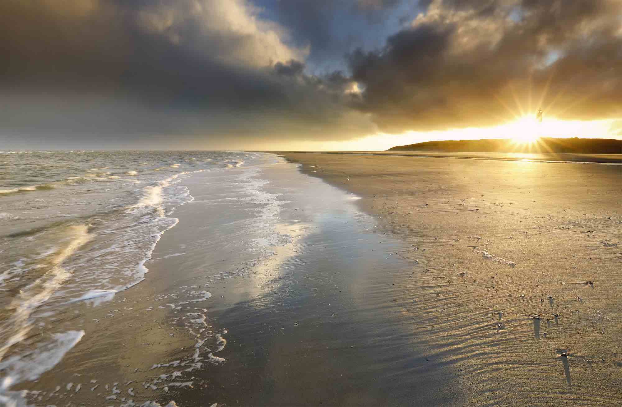 gold sunrise over North sea coast on Texel island